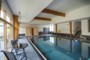 a large swimming pool with a table and chairs at House 47 in Talland