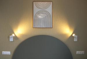 a room with a painting on the wall and two lights at Résidence Bordeaux Sud Pessac in Pessac