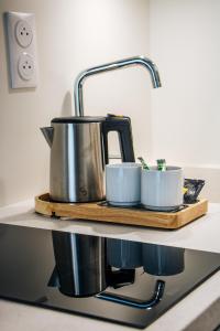 a kitchen counter with a tea pot and two cups at Résidence Bordeaux Sud Pessac in Pessac