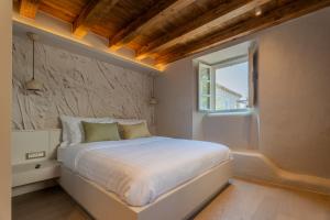 a bedroom with a white bed and a window at Maxima Comoda luxury villa in Dubrovnik