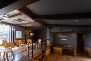 富士河口湖Kawaguchiko Country Cottage Ban的一间设有桌椅的房间,位于一个墙上