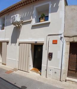 een wit gebouw met een deur en een raam bij La Bohème in Eyragues