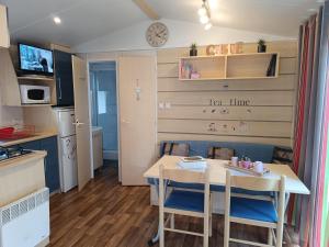 a small kitchen with a table and chairs in a room at Le Guiness proche Europa Park et Rulantica in Boofzheim