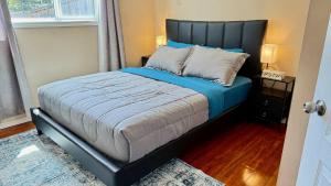 a bedroom with a bed with blue sheets and pillows at The Panatella Pad /Guest’s Private Suite in Calgary