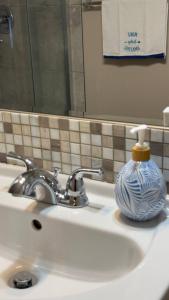 a bathroom sink with a blue and white vase on it at The Panatella Pad /Guest’s Private Suite in Calgary +49 photos