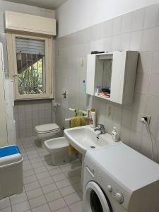 een badkamer met toilet, wastafel en wasmachine bij Residence Leonardo sul mare in Silvi Marina +105 foto's