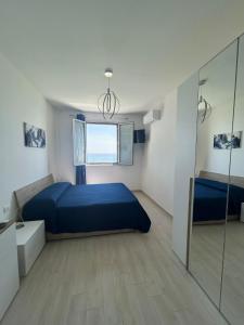 a bedroom with a blue bed and a mirror at Villa Alena in Montallegro
