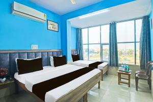 een slaapkamer met 2 bedden en een blauwe muur bij Hotel O by OYO Deep in Kānota