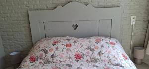 a white bed with a floral comforter on it at De Âlde Bibleteek in Burgum