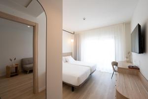 a bedroom with a white bed and a window at Hotel RH Arena - Todo Incluido in Gandía