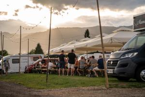 a group of people sitting at tables under tents at Schitterhof CAMPING WEISS in Spielberg