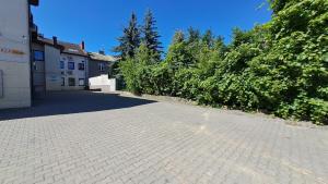 a cobblestone parking lot in front of a building at Hostel Centrum in Końskie
