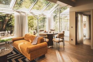 a conservatory with a couch and a table and chairs at Parc Victoria Appartements in Saint-Jean-de-Luz