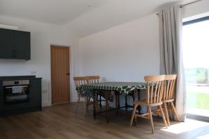 a kitchen with a table with chairs and a window at The Stables in Sibbertoft +5 photos