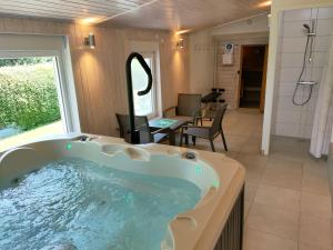 a jacuzzi tub in the middle of a room at Gîte 829 Montagnes du Jura avec Spa et Sauna classé 3 étoiles in Foncine-le-Haut