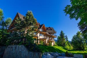 a large house on top of a hill with trees at Cyrhla przy szlaku in Zakopane