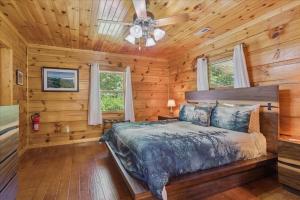 a bedroom with a bed and a ceiling fan at Chasing Cubs Cabin By Beyond Expectations in Sevierville