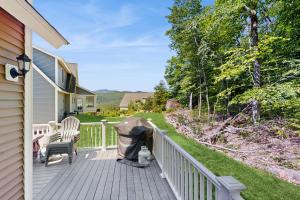 a wooden deck with a chair on a house at Beechwoods Mountain Living in Intervale
