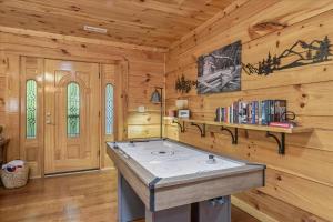 a kitchen with a stove in a log cabin at Chasing Cubs Cabin By Beyond Expectations in Sevierville +43 photos