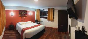 una camera da letto con un letto e una TV a schermo piatto di Hotel Cusco Museo a Cuzco