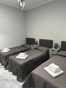 a room with three beds with towels on them at Nardhouse in Carrao