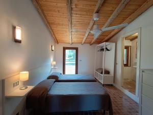 罗迪-加尔加尼科Tenuta Molino di Mare- Ecoresort的一间带两张床和吊扇的卧室