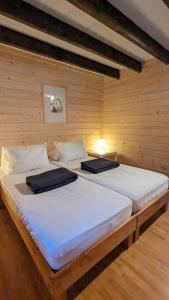 2 Einzelbetten in einem Zimmer mit Holzwänden in der Unterkunft Chalets de vacances Castelwood in Biron