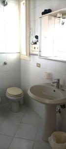 a white bathroom with a toilet and a sink at Villa Valchiria in Campomarino