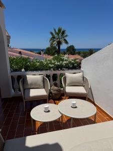 een terras met twee tafels en twee stoelen op een balkon bij 3 Bedroom Villa, San Jaime, Son Bou in Son Bou