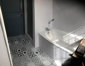 a bathroom with a bath tub and a tile floor at Baudelocque in Boulogne-sur-Mer +43 photos