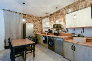 una cucina con un tavolo, una stufa e un lavandino di Flat village Saint-Paul-de-Vence 4P a Saint-Paul-de-Vence