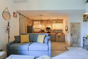 un soggiorno con un divano blu e una cucina di Flat village Saint-Paul-de-Vence 4P a Saint-Paul-de-Vence
