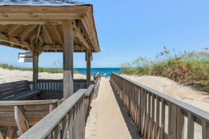 a wooden boardwalk to the beach with a pavilion at Quite Right in Nags Head