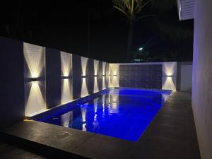 a swimming pool at night with blue lighting at CASA KM Beach Pool Access in Dauis