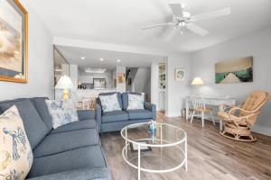 a living room with a couch and a table at Quite Right in Nags Head +29 photos