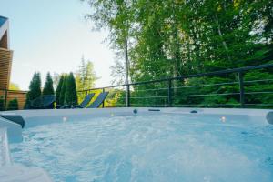 a jacuzzi tub on a balcony with trees at Golden Wood in Sovata