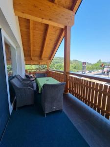 a porch with chairs and a green table on it at Ferienwohnung Traisen Has in Traisen +9 photos