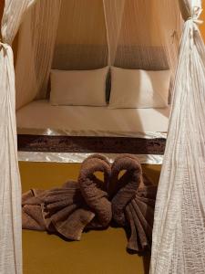 a bed with two snakespretending to be hearts at Balé Sebaya - Bungalows Café Nature in Senaru