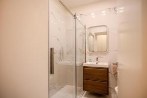 a white bathroom with a shower and a sink at Doria Chic Studio in Turin
