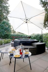 a table with plates of food and an umbrella at Tognazzi Casa Vacanze - Dimora Bunny e Danny in Villa del Monte