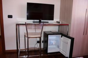 una scrivania con sedia e una televisione sopra di B&B le Pleiadi Aeroporto Fiumicino a Fiumicino