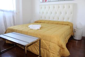 una camera da letto con un grande letto con una coperta gialla di B&B le Pleiadi Aeroporto Fiumicino a Fiumicino