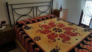 a bed with a comforter on top of it at Casa di Nonna in Calasetta