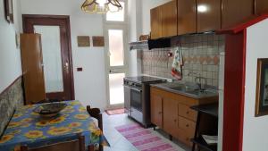 a kitchen with a table and a stove and a sink at Casa di Nonna in Calasetta