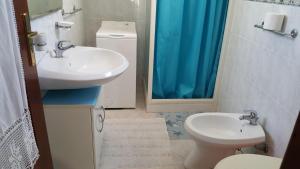 a bathroom with a sink and a toilet and a mirror at Casa di Nonna in Calasetta