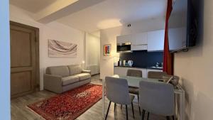 un soggiorno con tavolo e sedie e una cucina di Suite Cavour a Torino