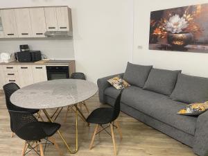 a living room with a couch and a table with chairs at Răsărit la epava in Costinesti