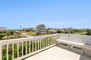 a bench on a balcony overlooking the ocean at RoSea Retreat in Nags Head