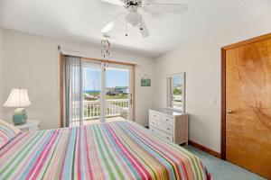 a bedroom with a bed and a balcony at RoSea Retreat in Nags Head