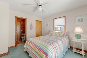 a bedroom with a bed and a ceiling fan at RoSea Retreat in Nags Head